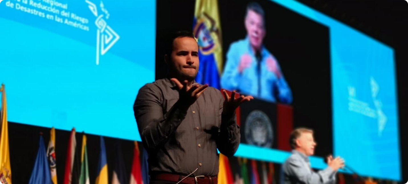 Colombian Sign Language interpreter signs at international conference in Cartagena, Colombia, while Santos speaks